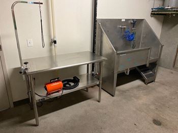 A stainless steel work table with a red container on it.